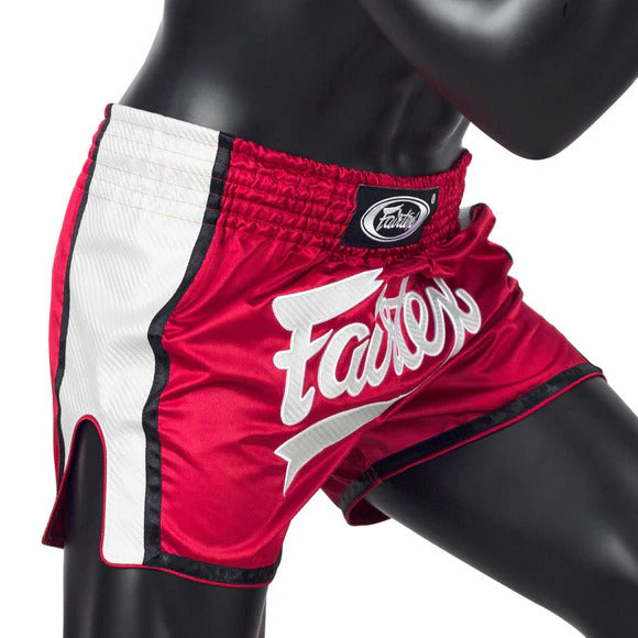 Red and white Muay Thai shorts with 'Fairtex' branding on a mannequin.
