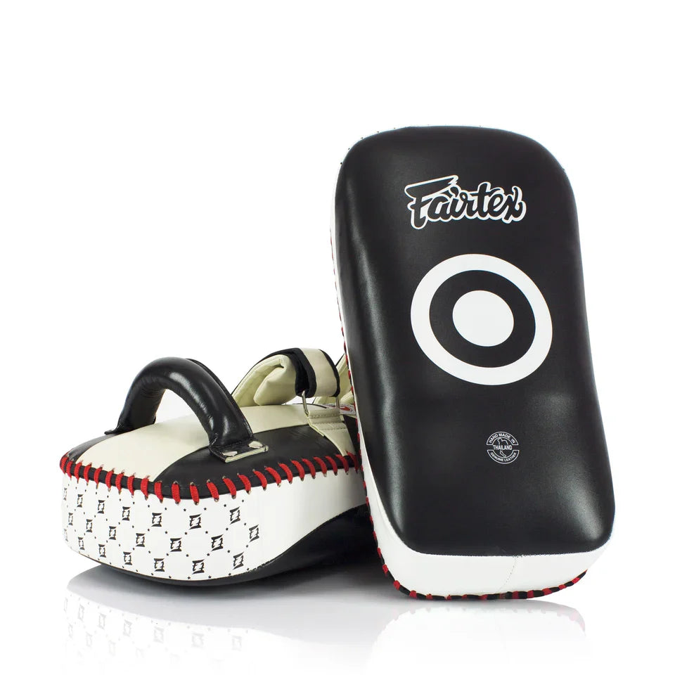 Pair of black and white Muay Thai pads with 'Fairtex' branding on a white background.