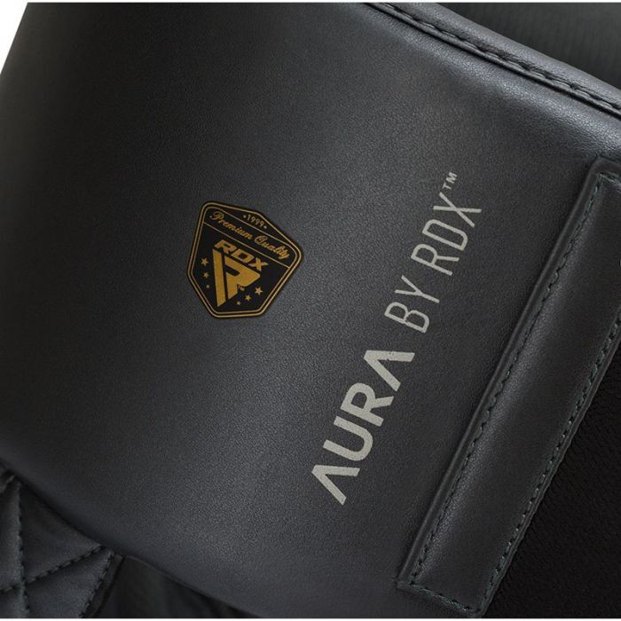 Close up of a black groin guard with 'RDX' branding on a dark background
