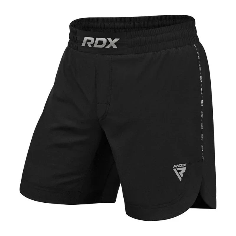 Black athletic MMA shorts with RDX branding on a white background