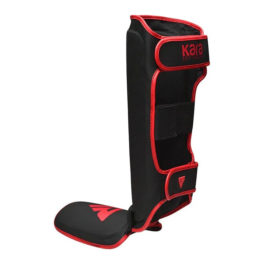 Black shin guard with red accents on a white background