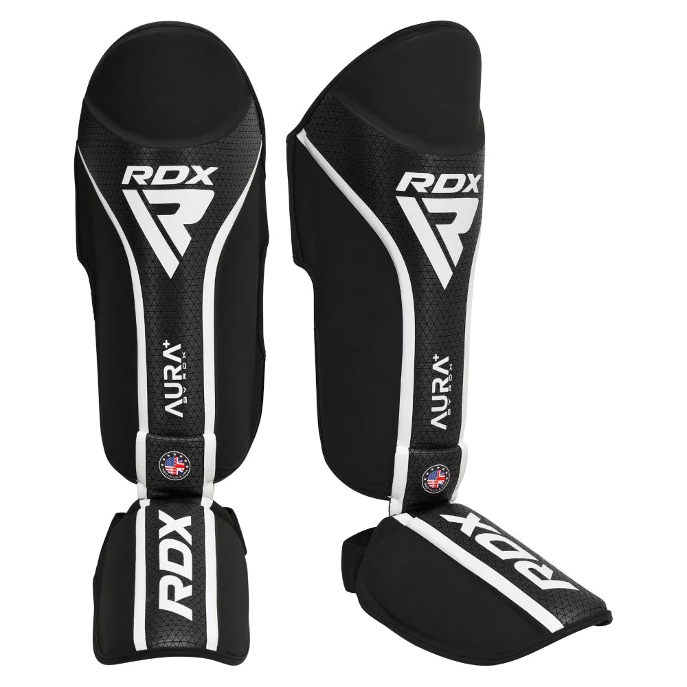 Black RDX shin guards with white accents on a white background