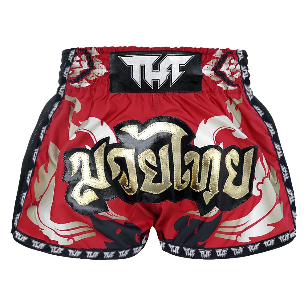 Red Muay Thai shorts with gold and black designs on a white background