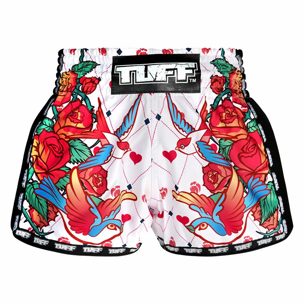 Colorful Muay Thai shorts with tattoos and roses design on a white background, featuring the brand 'TUFF'.
