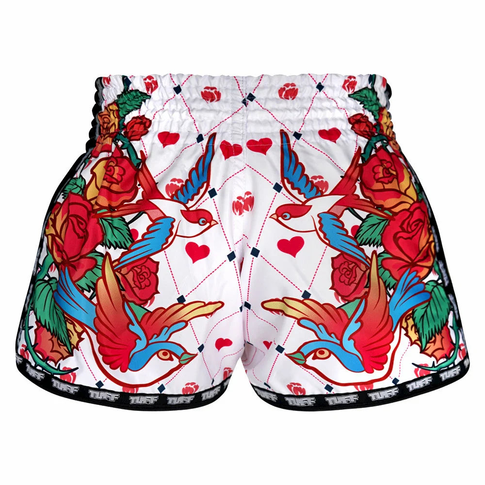 Colorful Muay Thai shorts with floral and bird design on a white background