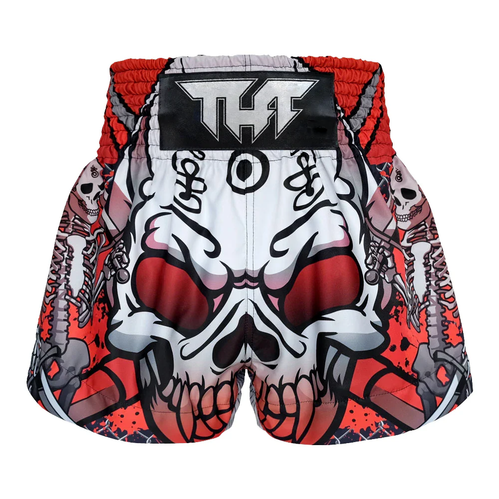 Muay Thai shorts with skull design and red accents on a white background