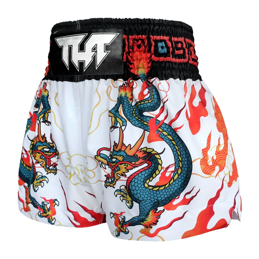 Muay Thai shorts with dragon design and visible brand logo on a white background