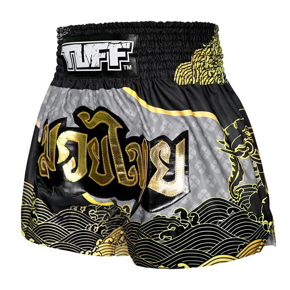 Black and gold Muay Thai shorts with 'TUFF' branding on a white background
