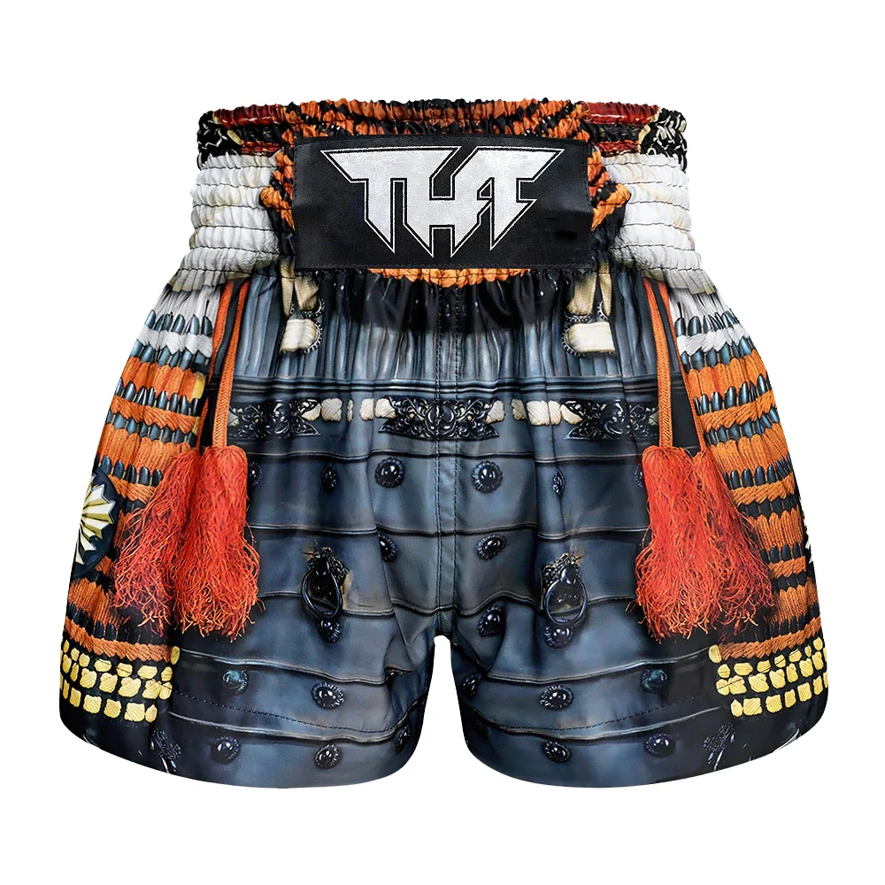 Decorative Muay Thai shorts with intricate patterns and a brand logo on a white background