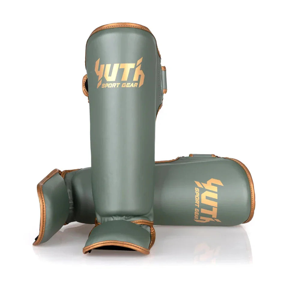 Green shin guards with brown accents on a white background, featuring 'YUTH Sport Gear' branding.
