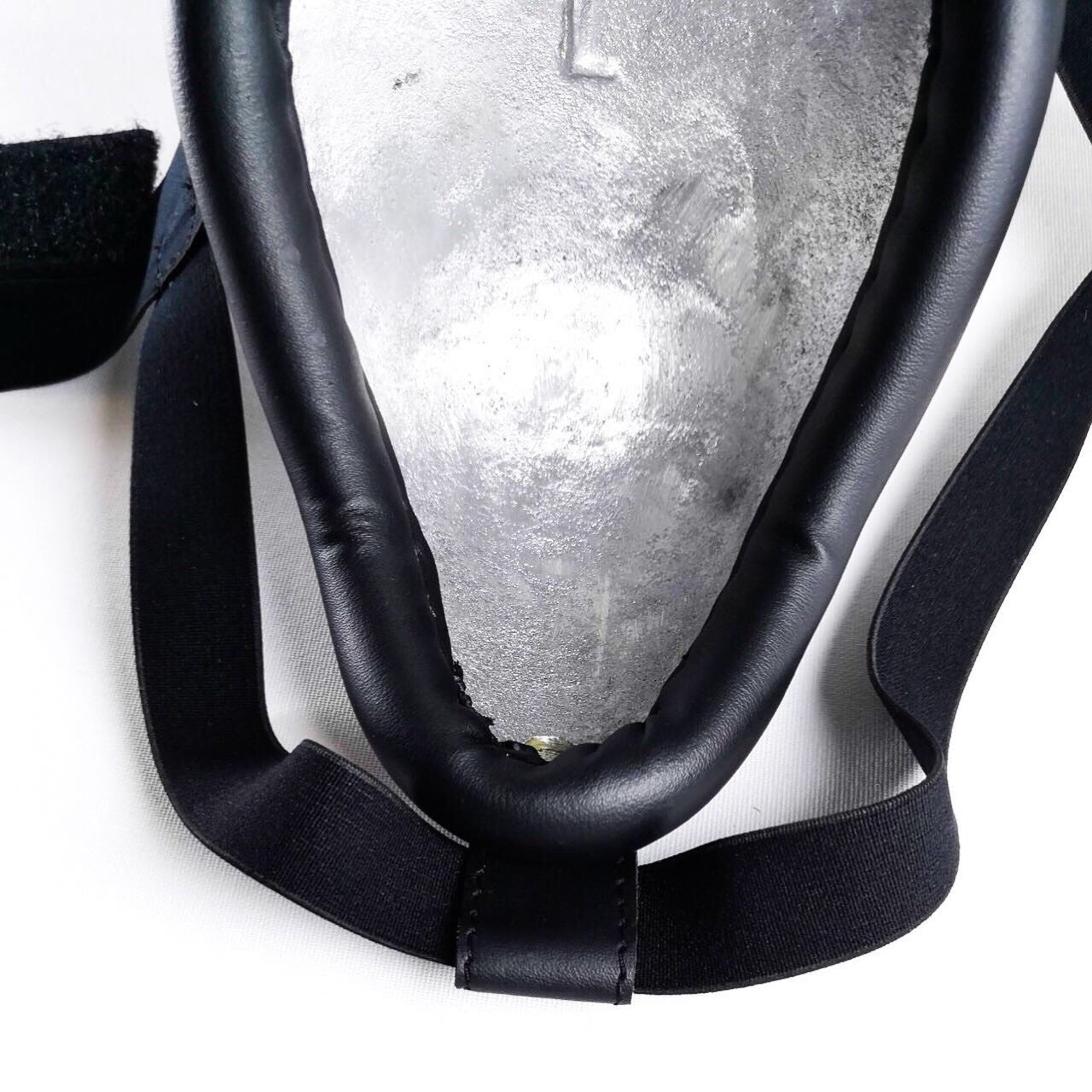 Close-up of a black groin guard with a white background