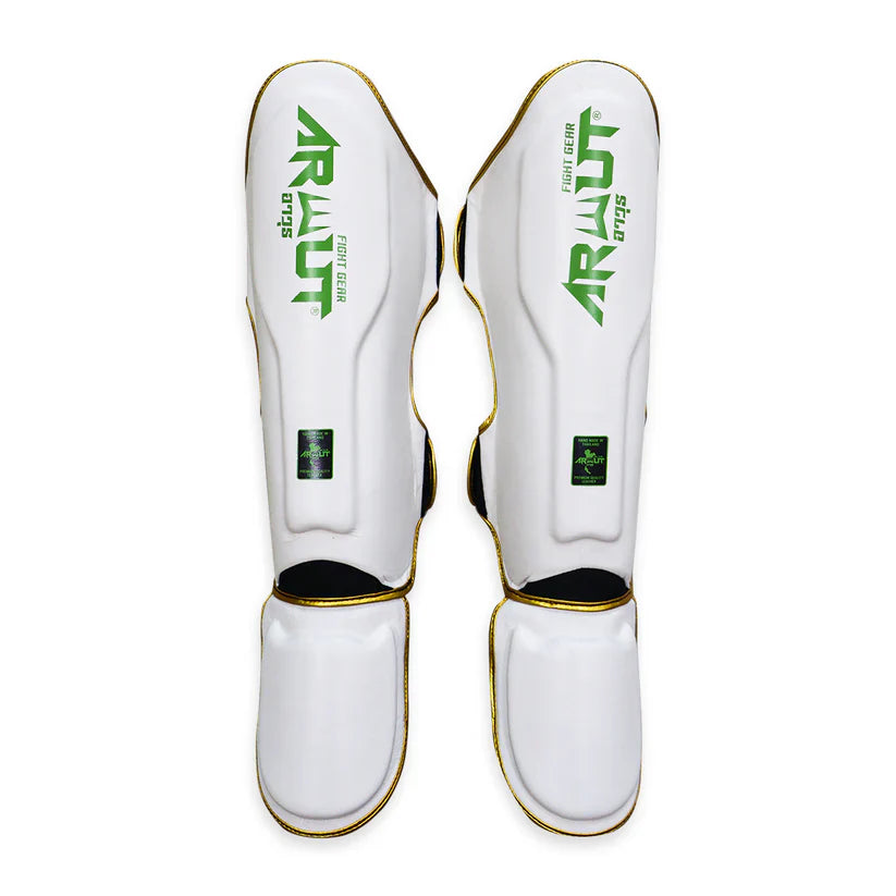 White shin guards with green and black branding on a white background