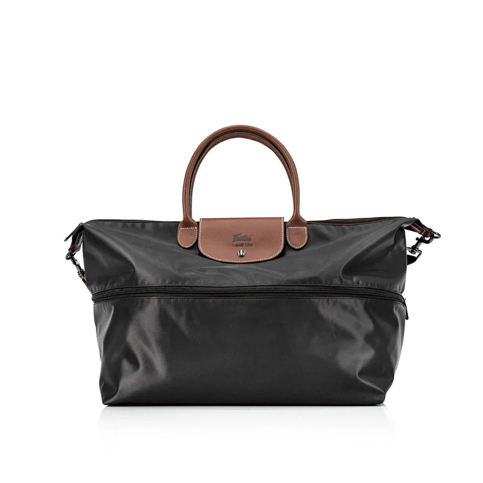 Black travel bag with brown leather handle and flap on a white background