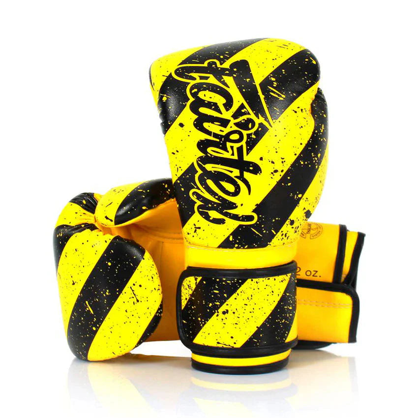 Yellow and black boxing gloves with 'Fairtex' branding on a white background