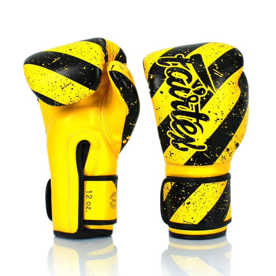 Yellow and black boxing gloves with 'Fairtex' branding on a white background