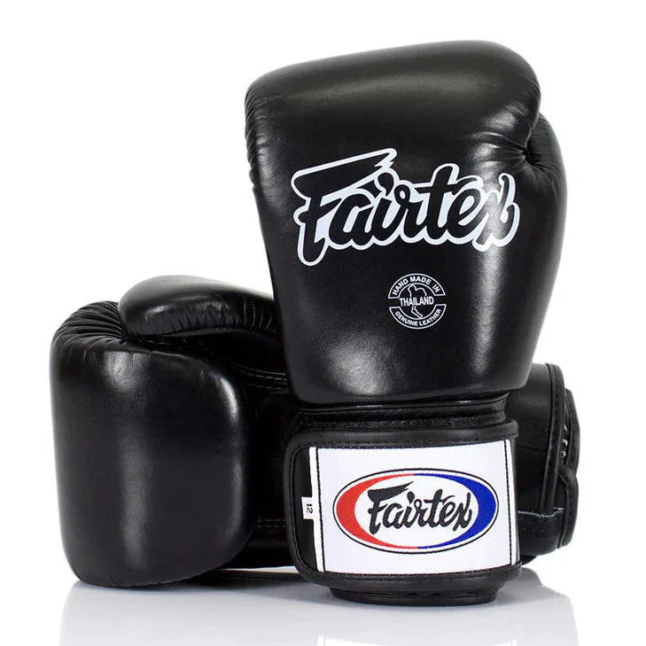 Black boxing gloves with Fairtex logo on a white background