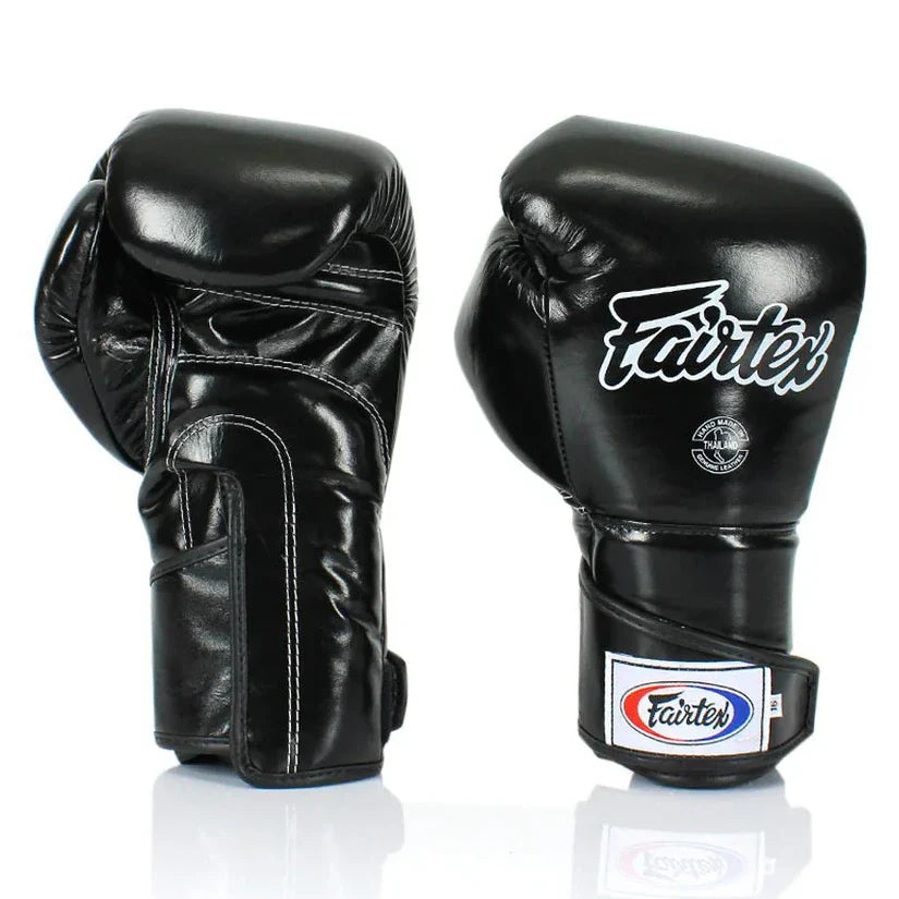 Pair of black boxing gloves with Fairtex logo on a white background