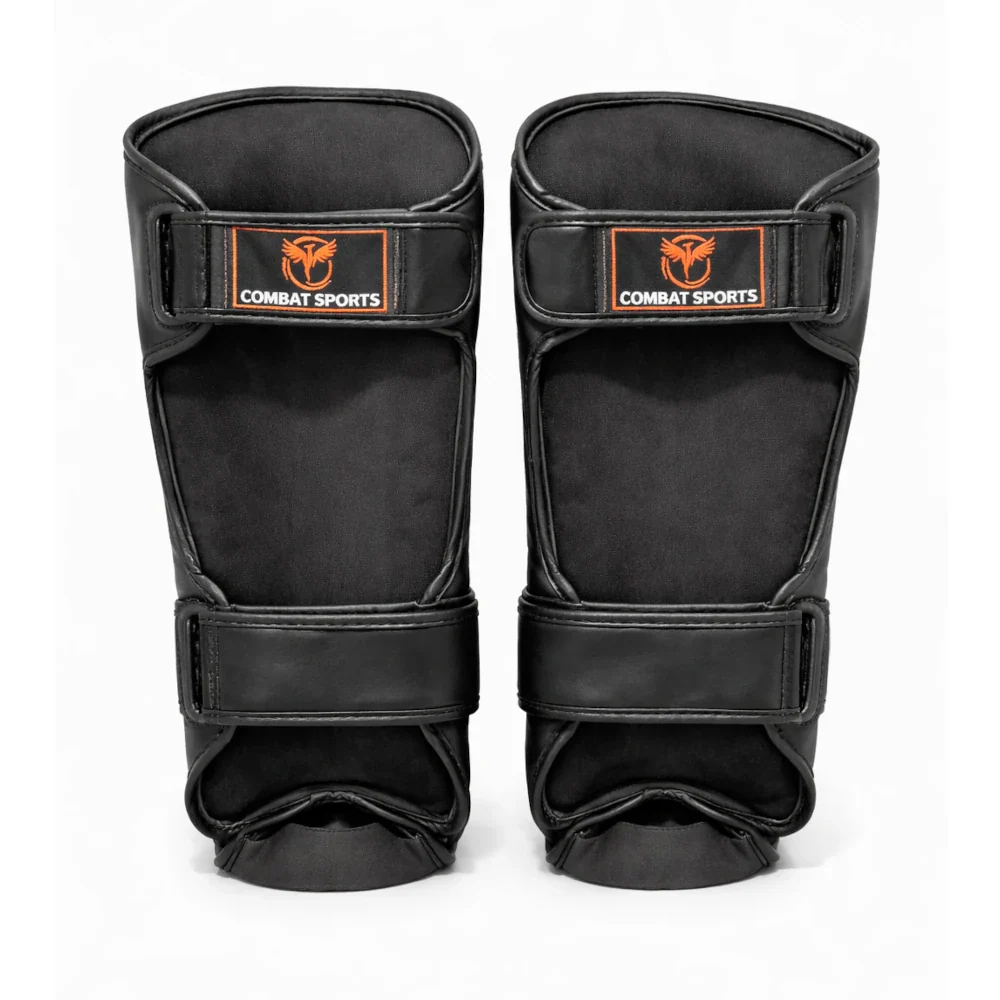 Pair of black shin guards with 'Combat Sports' branding on a white background
