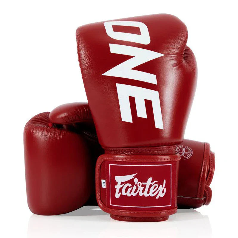 Red boxing gloves with 'ONE' and 'Fairtex' branding on a white background