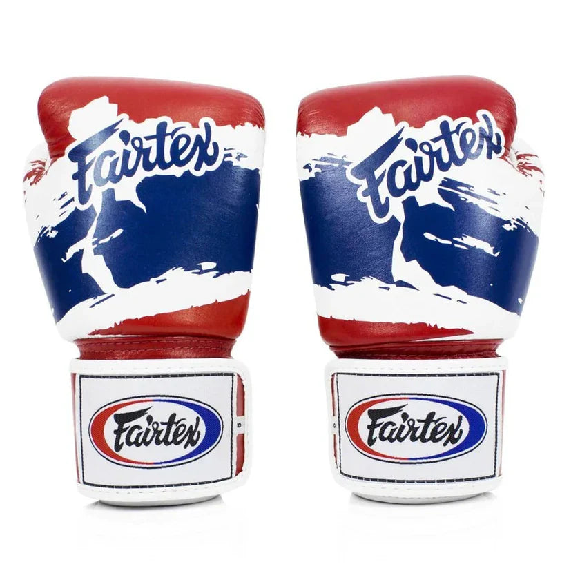 Pair of red, white, and blue Fairtex boxing gloves on a white background