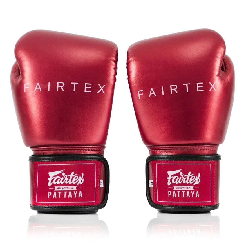 Red Fairtex boxing gloves on a white background