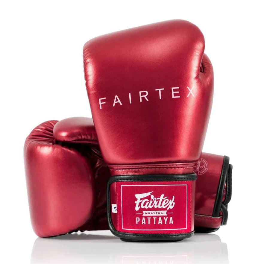 Red Fairtex boxing gloves on a white background