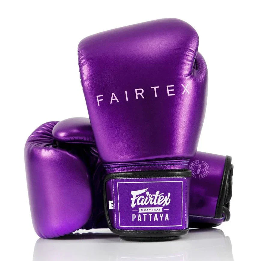 Purple boxing gloves with Fairtex branding on a white background