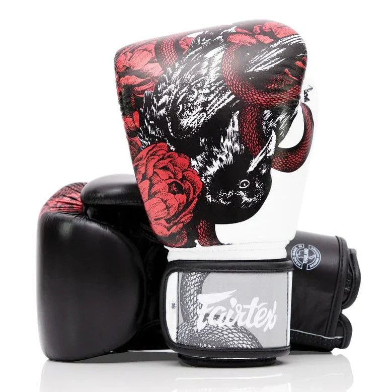 Black boxing glove with red and white floral and snake design on a white background