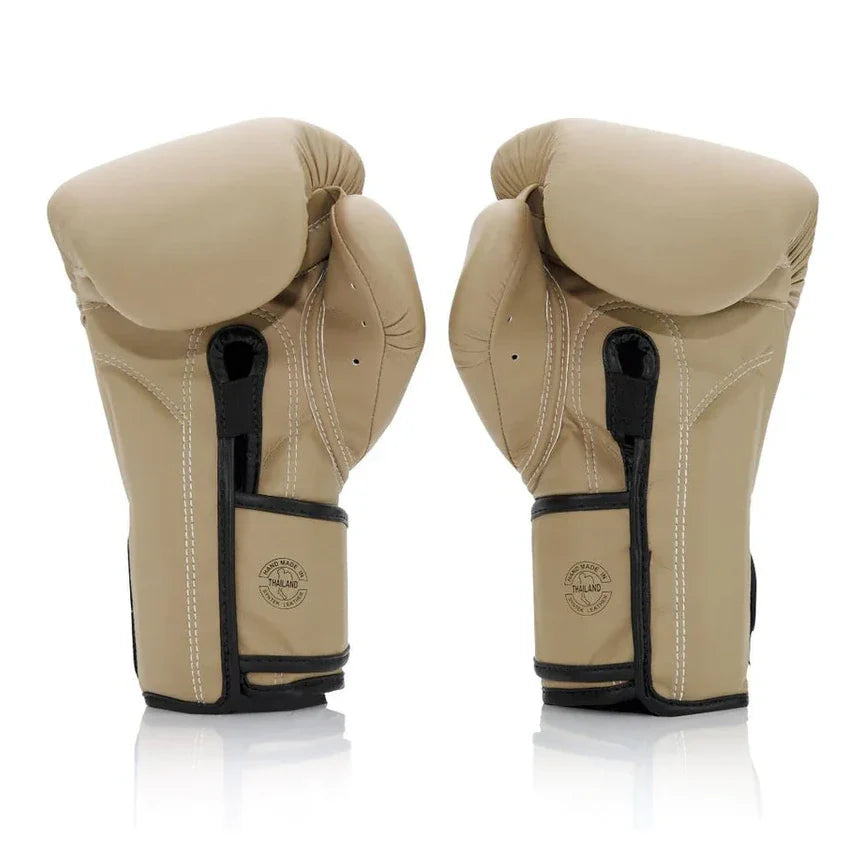 Pair of beige boxing gloves with black accents on a white background