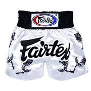 White Muay Thai shorts with black text and Fairtex logo on a white background