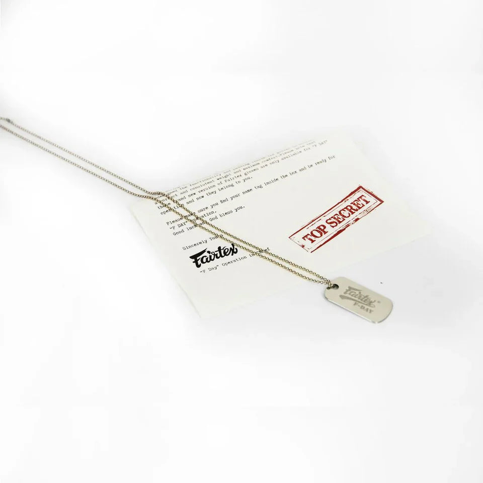 Gold necklace with a tag on a white card with text and a red stamp.