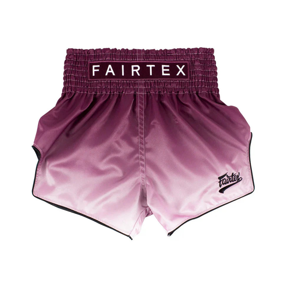 Pink boxing shorts with Fairtex branding on a white background