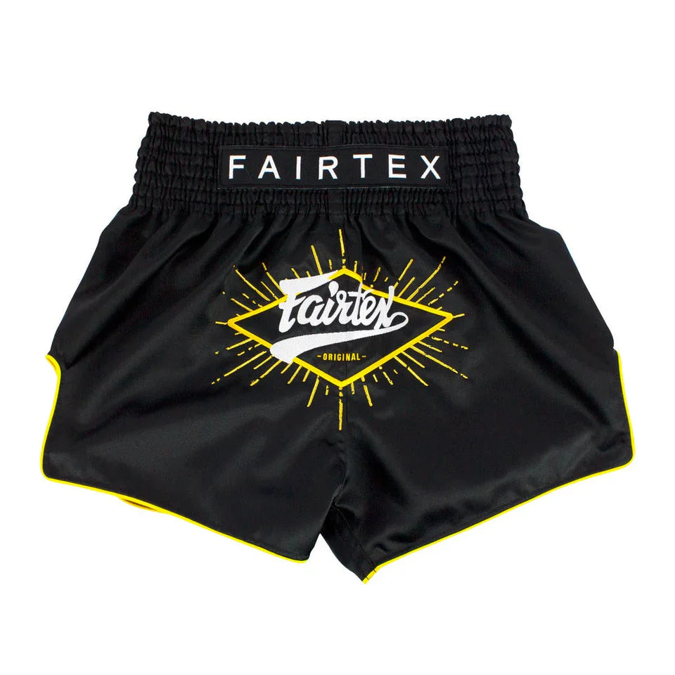 Black Fairtex shorts with yellow logo on a white background