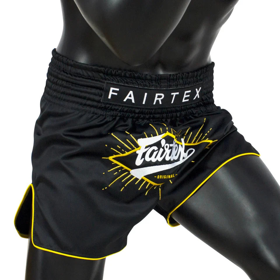 Black Fairtex shorts with yellow accents on a mannequin against a white background