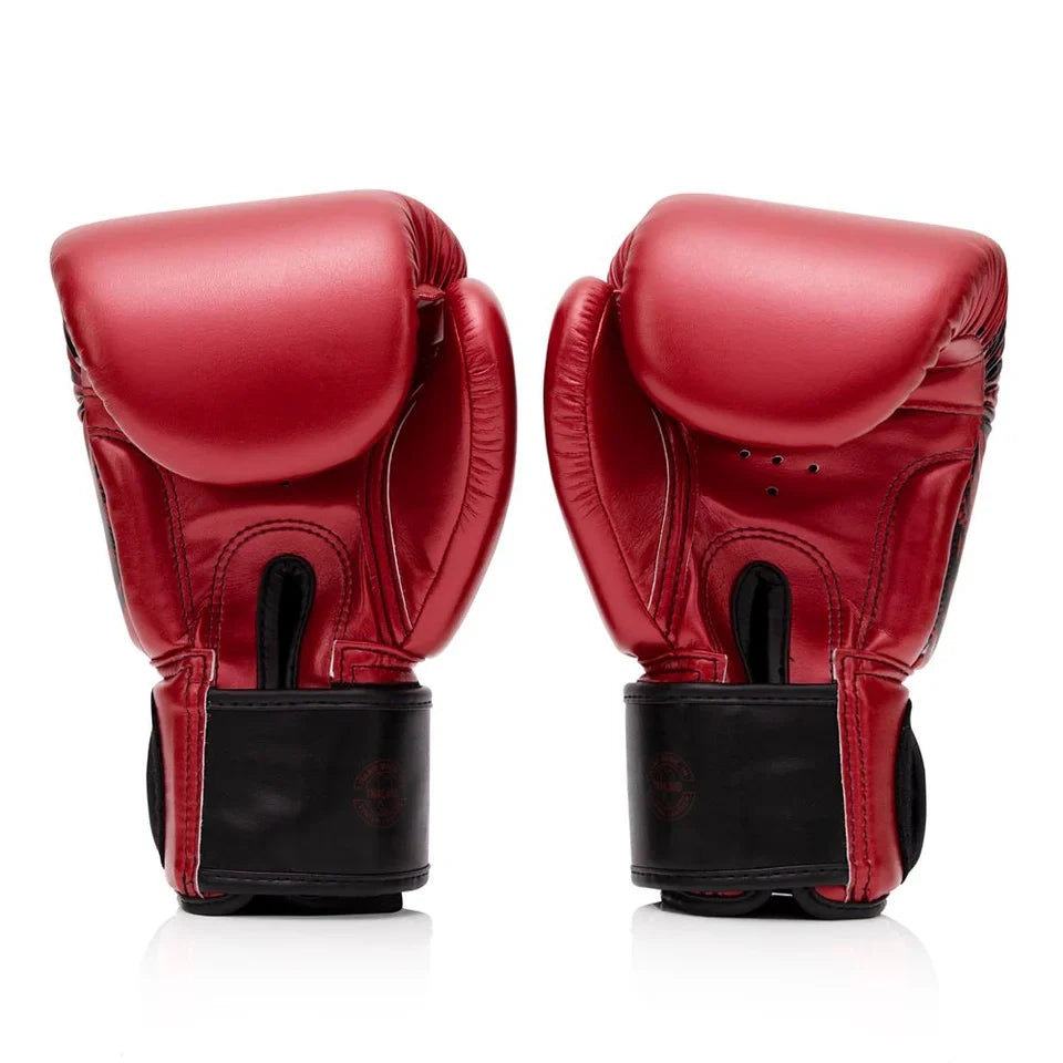 Pair of red boxing gloves with black cuffs on a white background