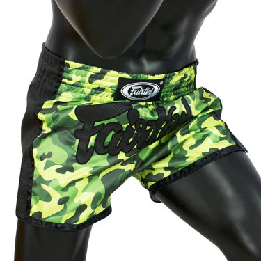 Green camouflage Muay Thai shorts with black logo on a mannequin against a white background