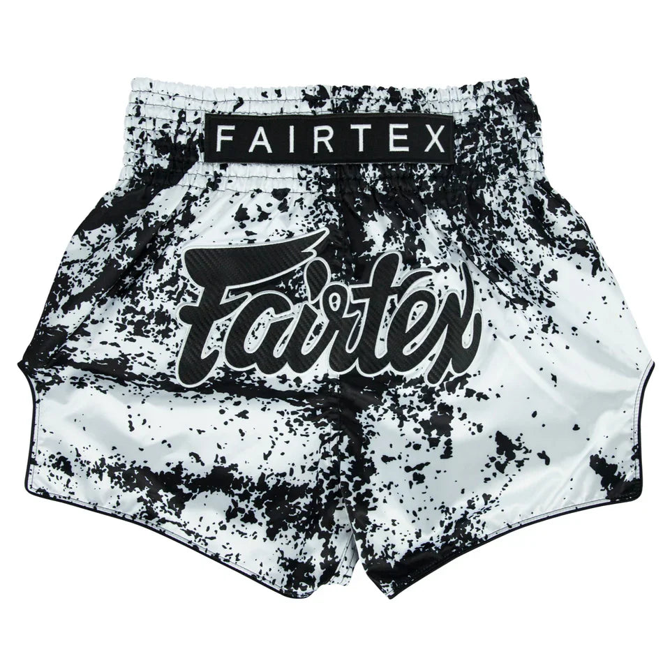 Black and white splatter-patterned boxing shorts with Fairtex branding on a white background