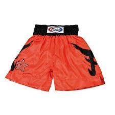 Orange boxing shorts with black star design on a white background