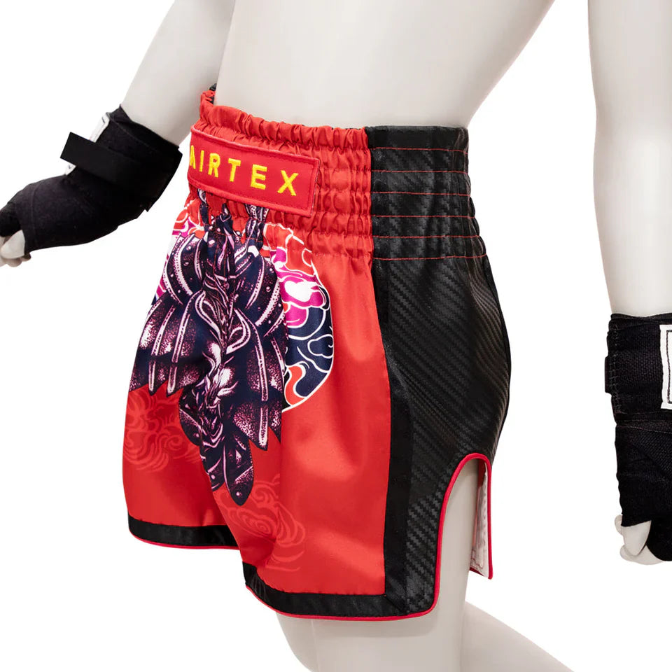 Red and black Muay Thai shorts with a colorful design on a white background