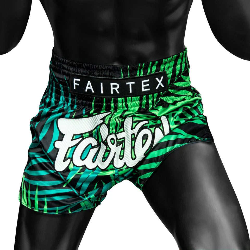 Green and black Fairtex boxing shorts on a white background