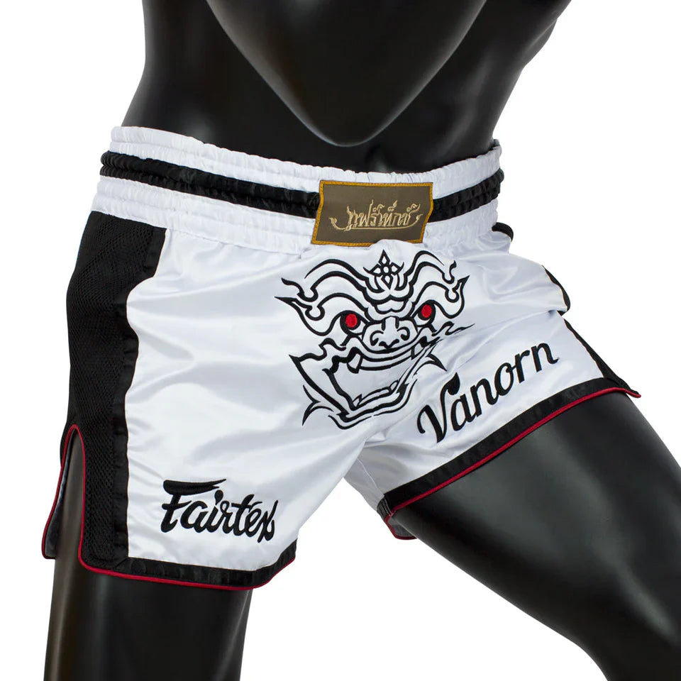 White and black Muay Thai shorts with Fairtex and Vanorn branding on a mannequin.
