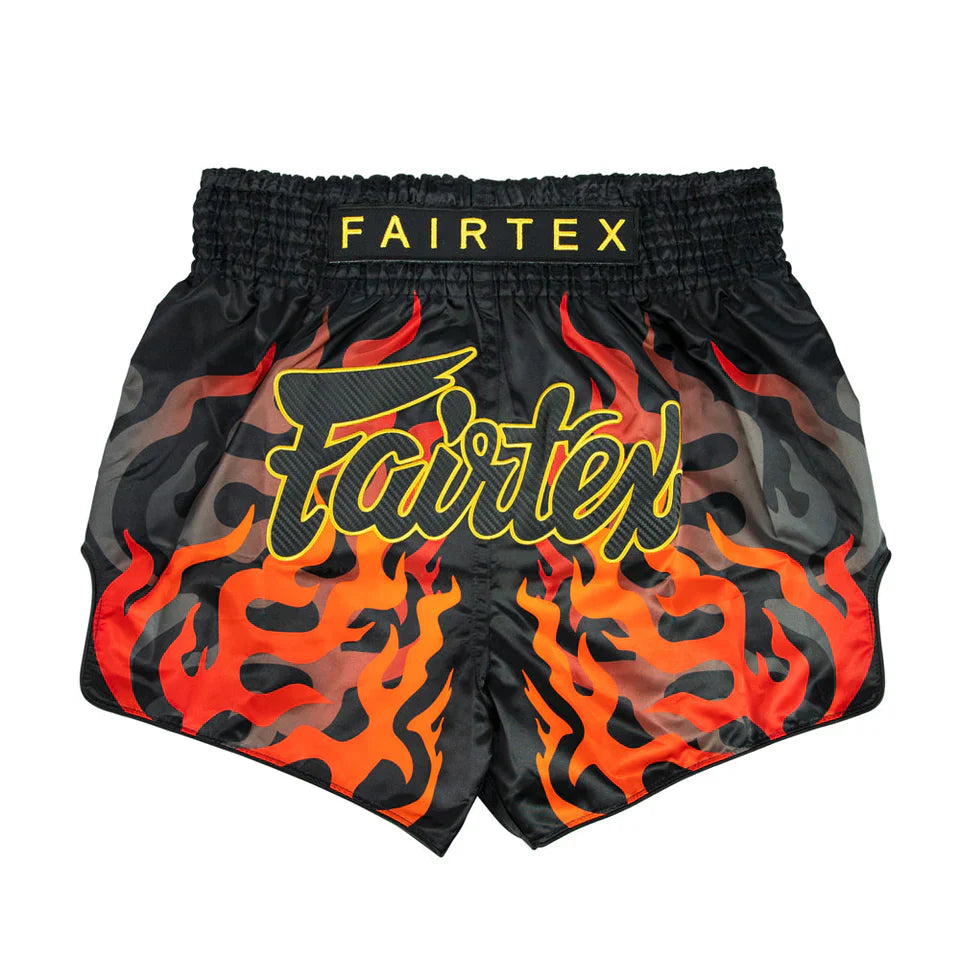 Black Muay Thai shorts with red flames and Fairtex branding on a white background