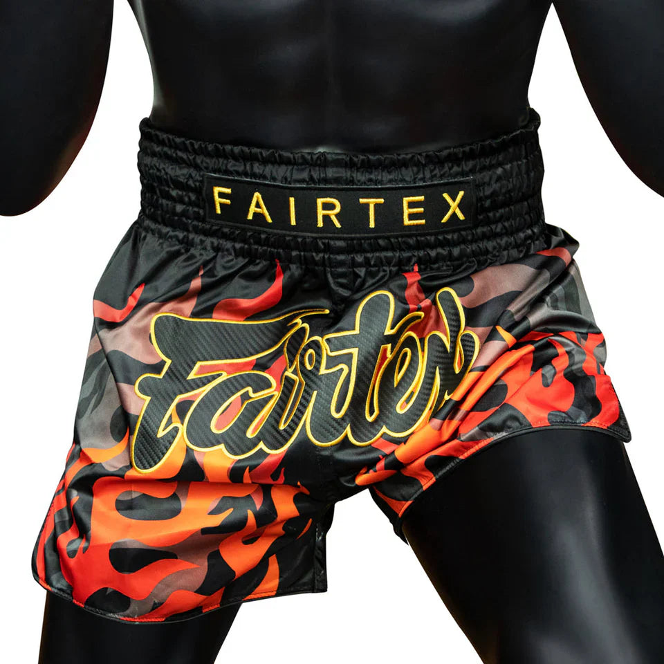 Black and red Muay Thai shorts with Fairtex branding on a white background