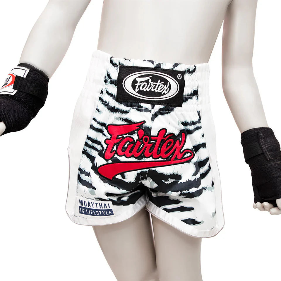 White and black zebra-striped boxing shorts with Fairtex branding on a white background.