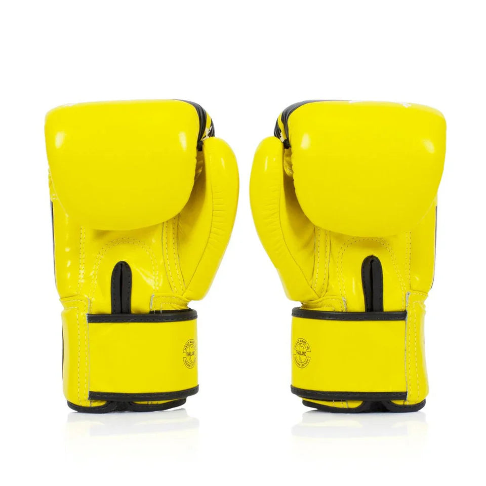 Pair of yellow boxing gloves with black accents on a white background
