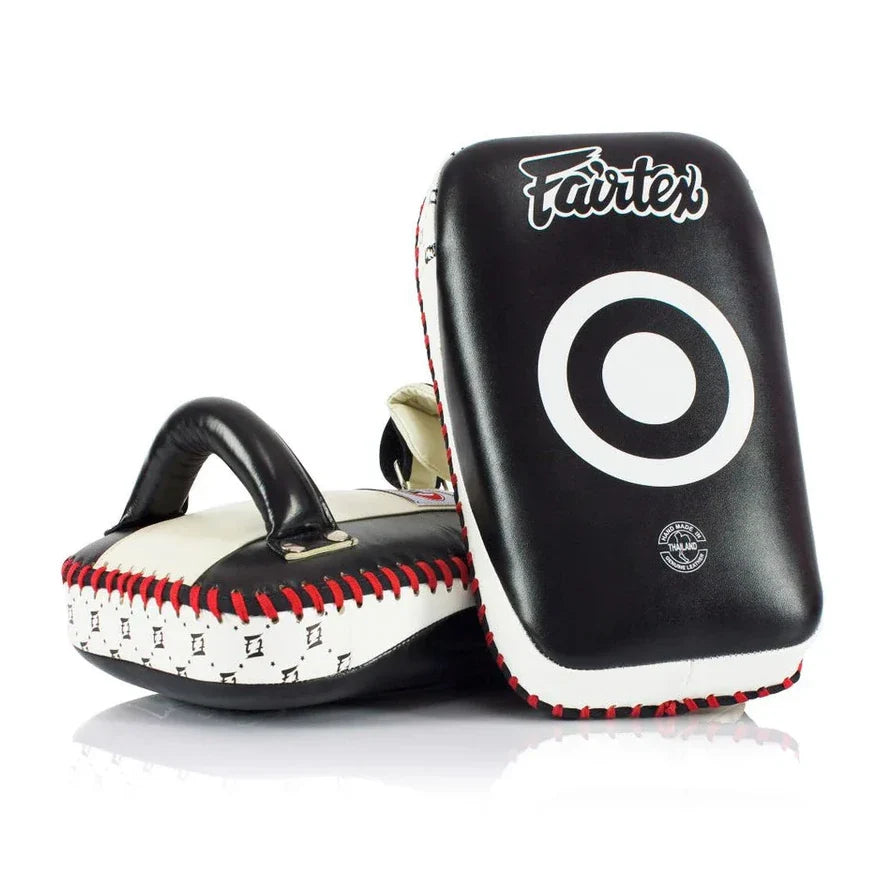 Pair of black and white Muay Thai pads with 'Fairtex' branding on a white background.