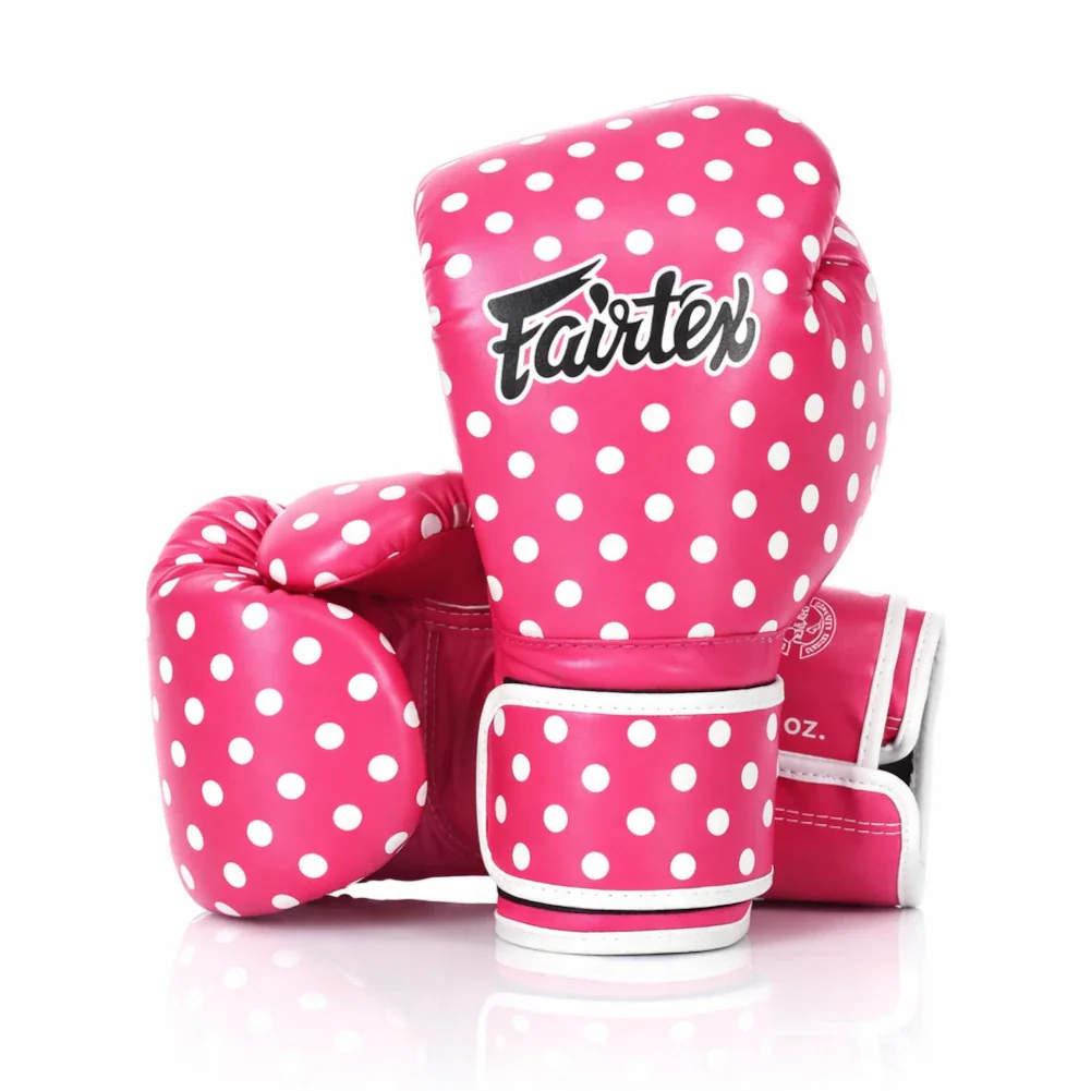 Pink boxing gloves with white polka dots and Fairtex branding on a white background