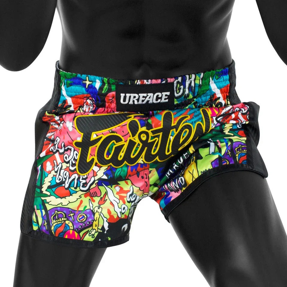 Colorful athletic Muay Thai shorts with graphic design and 'URFACE' branding on a black background