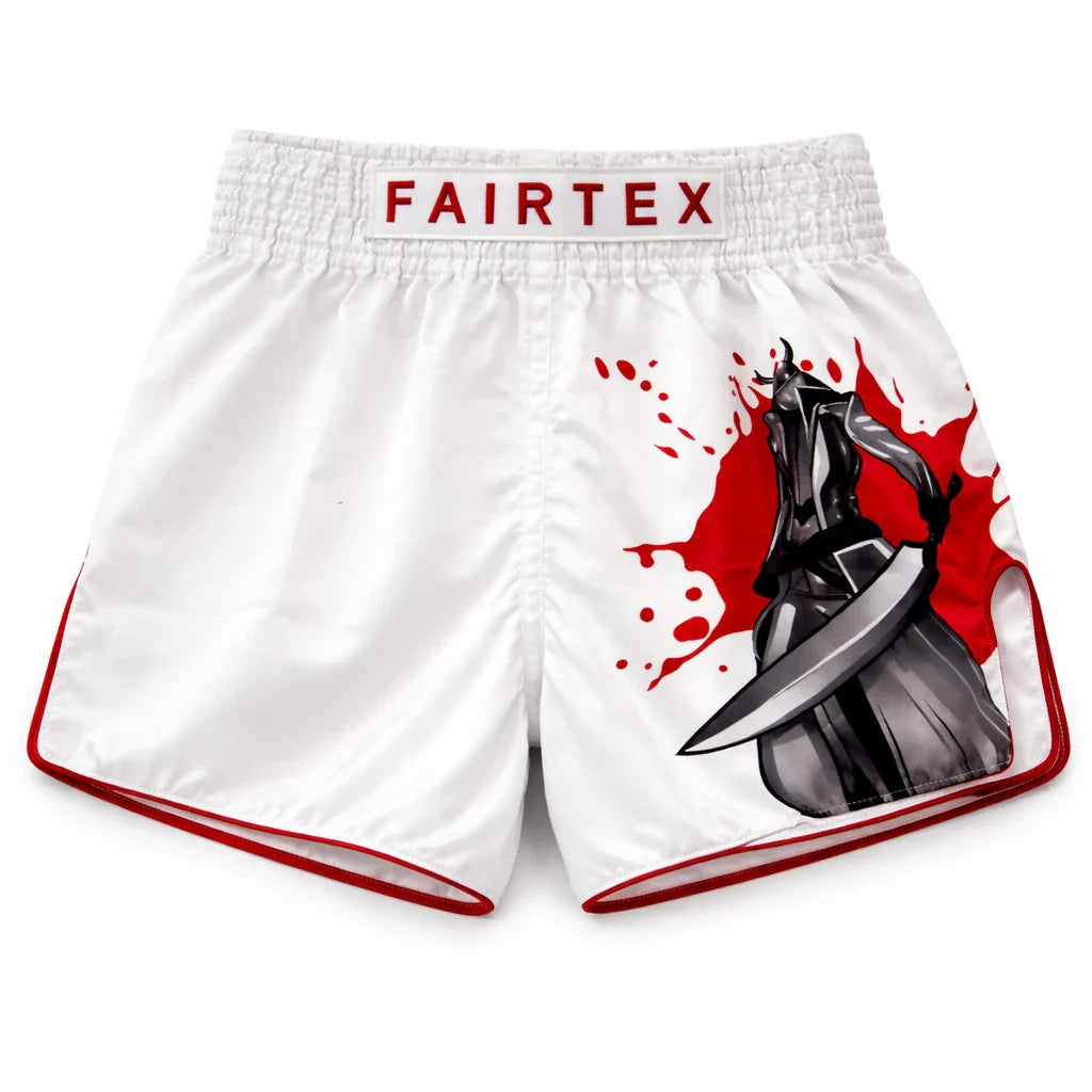 White boxing shorts with red accents and Fairtex branding, featuring a graphic design on the side.