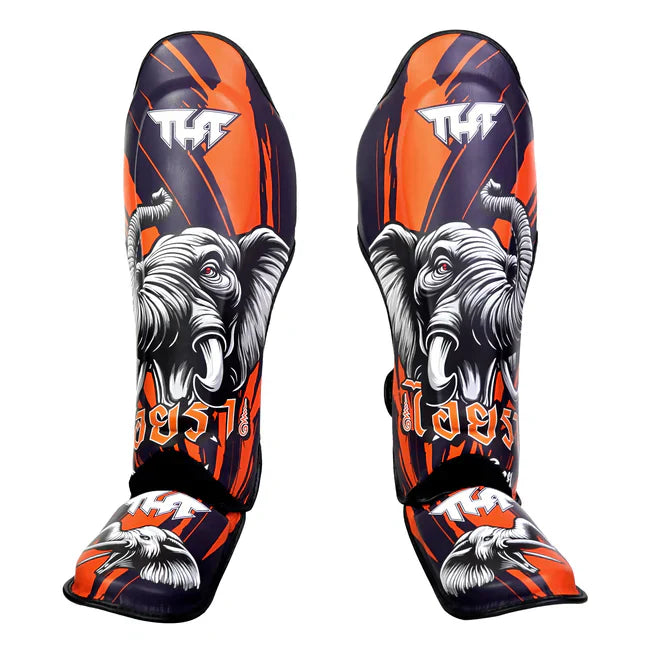 Pair of elephant-themed TUFF shin guards with orange, black, and white design on a white background.